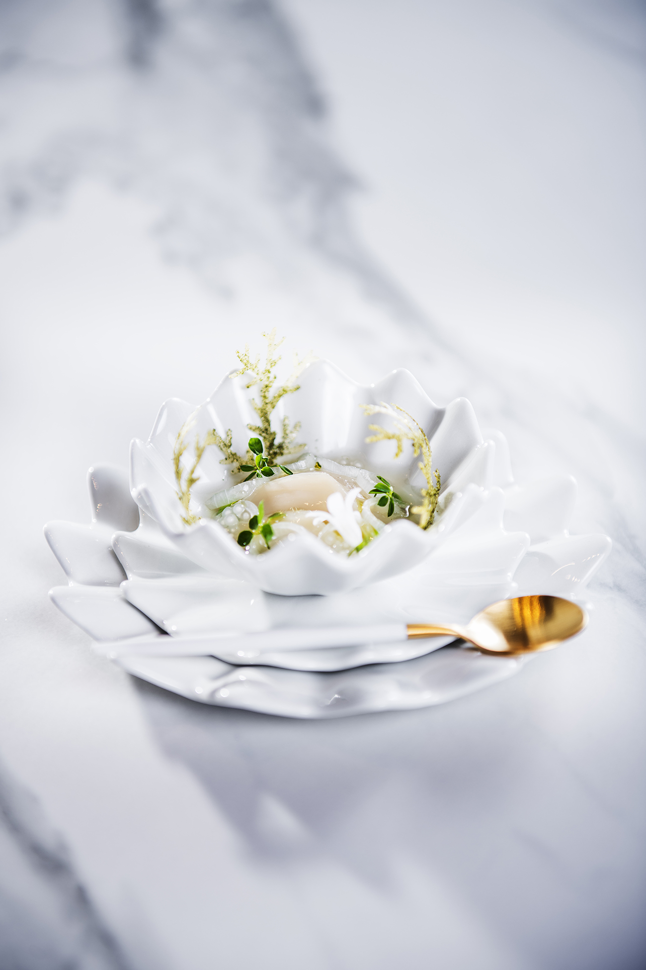 Blomstermat på hvitt plate med gullskje