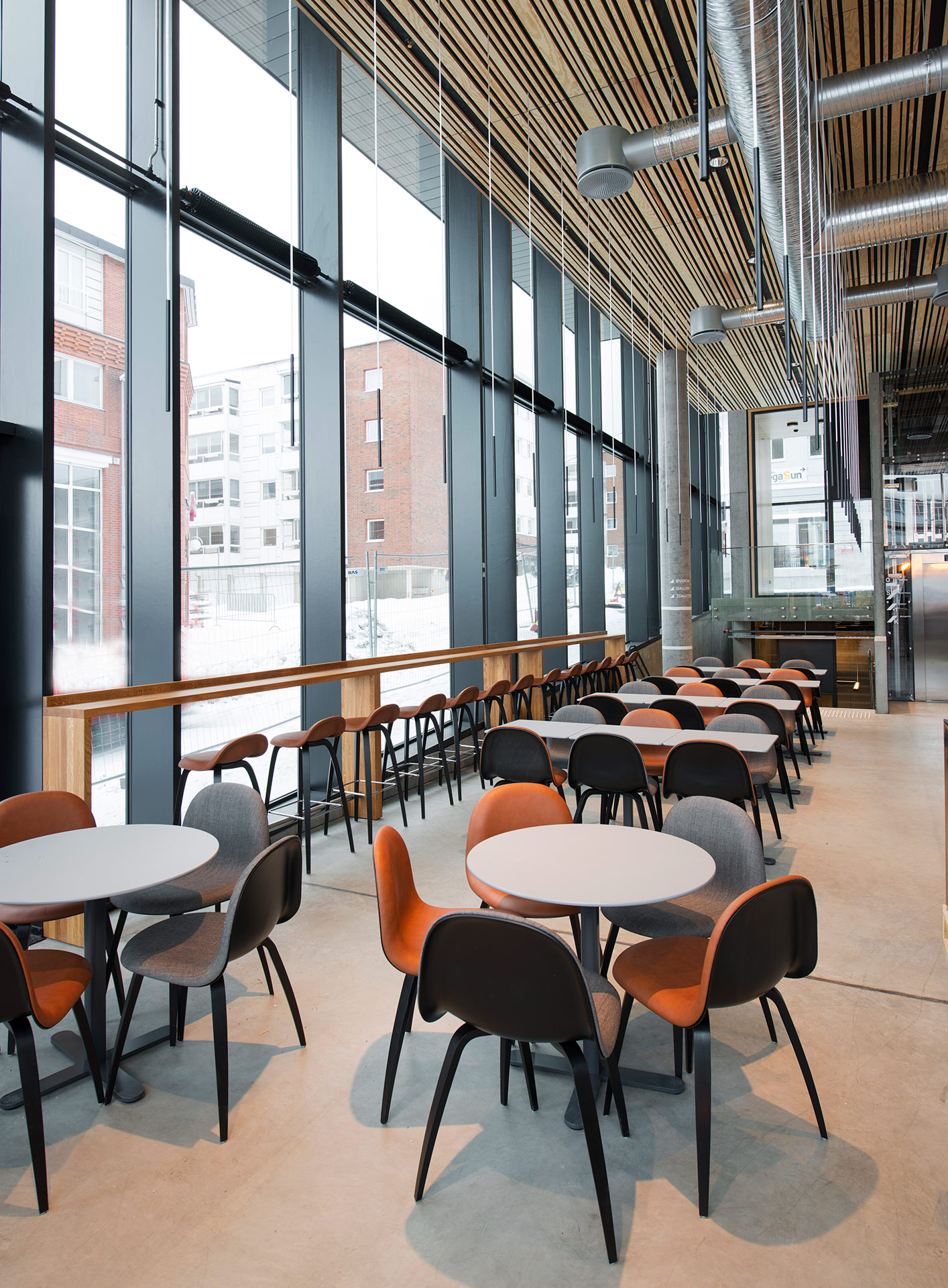 Moderne kantine med store vinduer og komfortable møbler