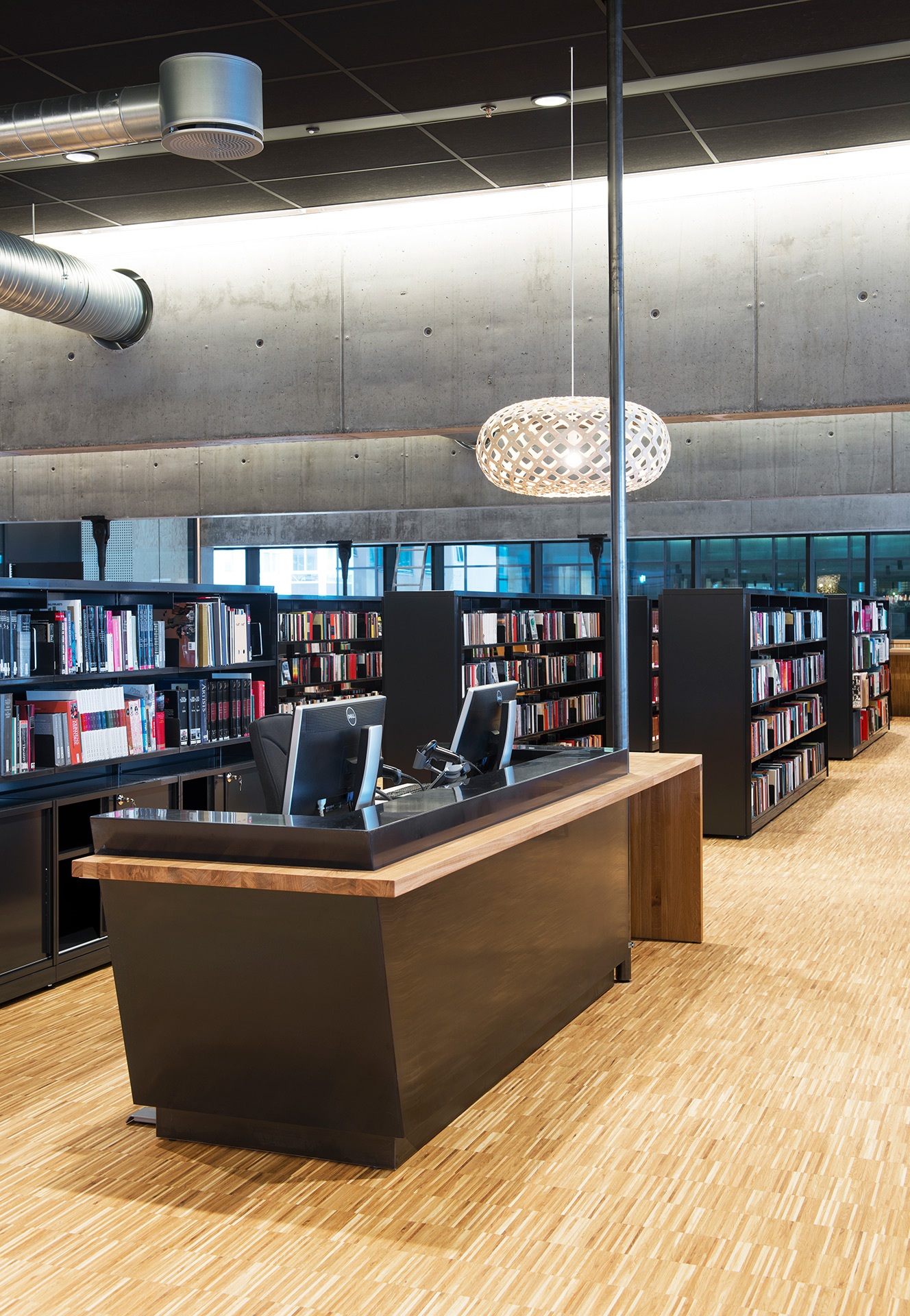 Moderne bibliotek med arbeidsstasjon og bokhyller