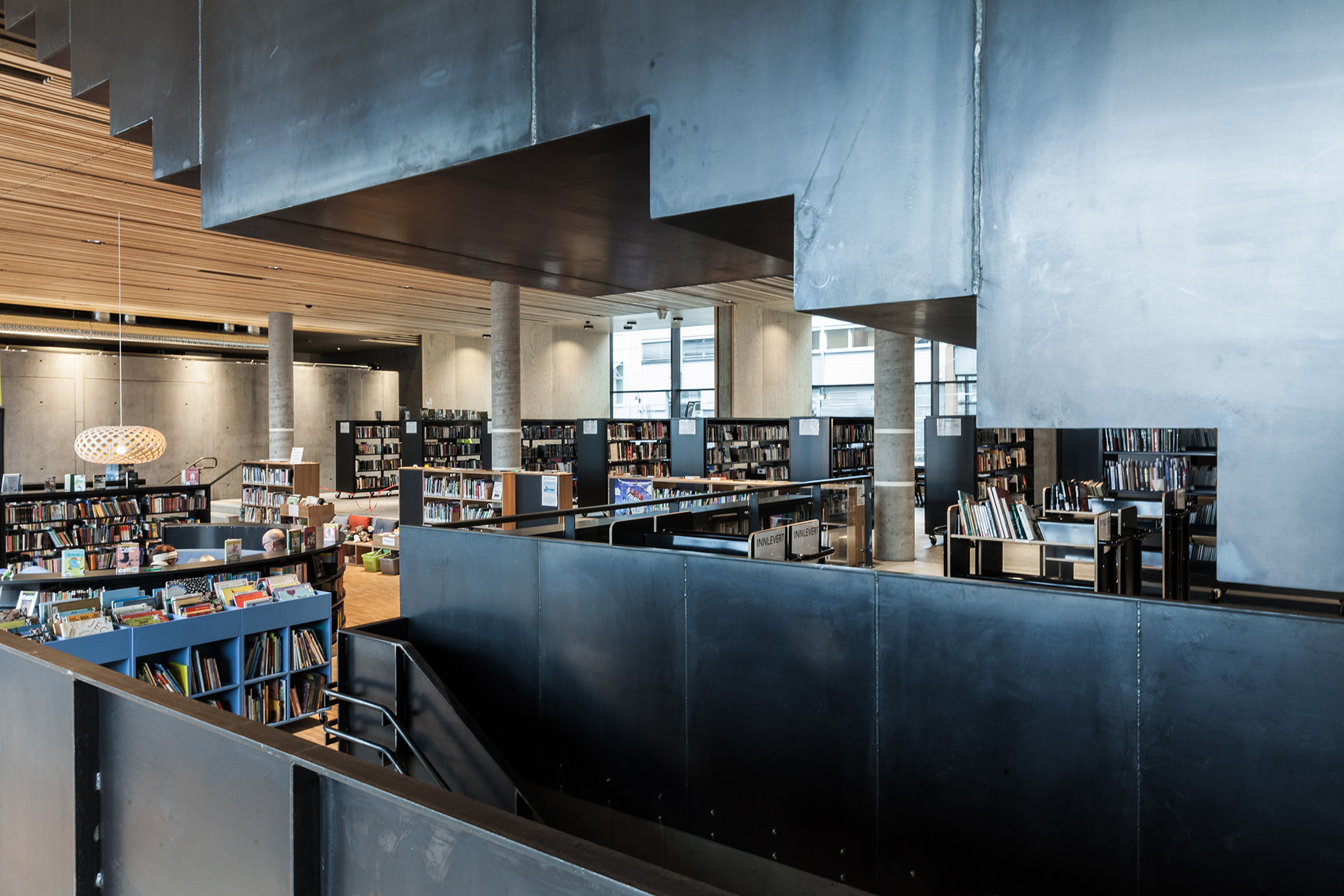 Bibliotek med mange bøker og åpne rom