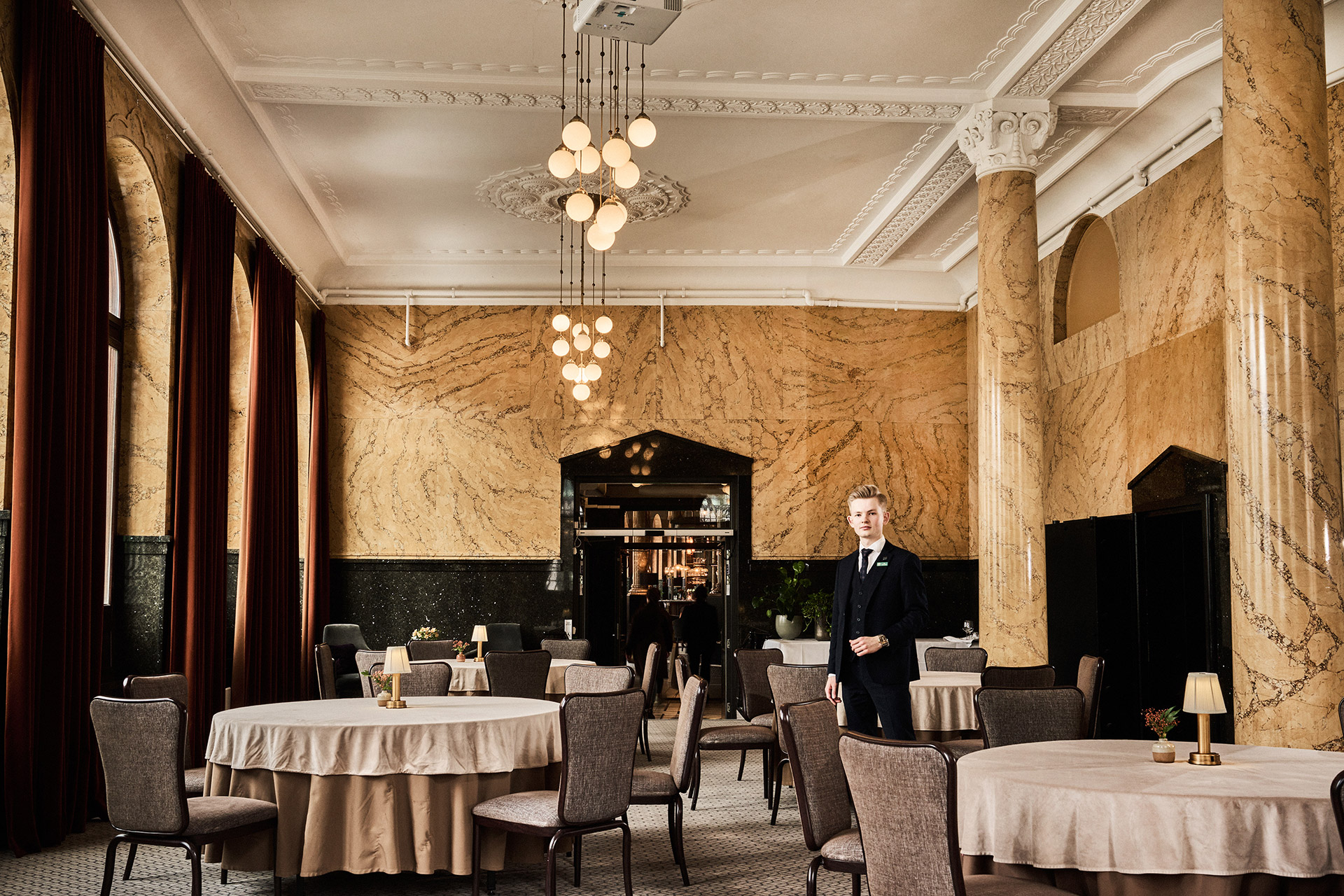 Luksuriøst hotellrom med servitør og spisebord