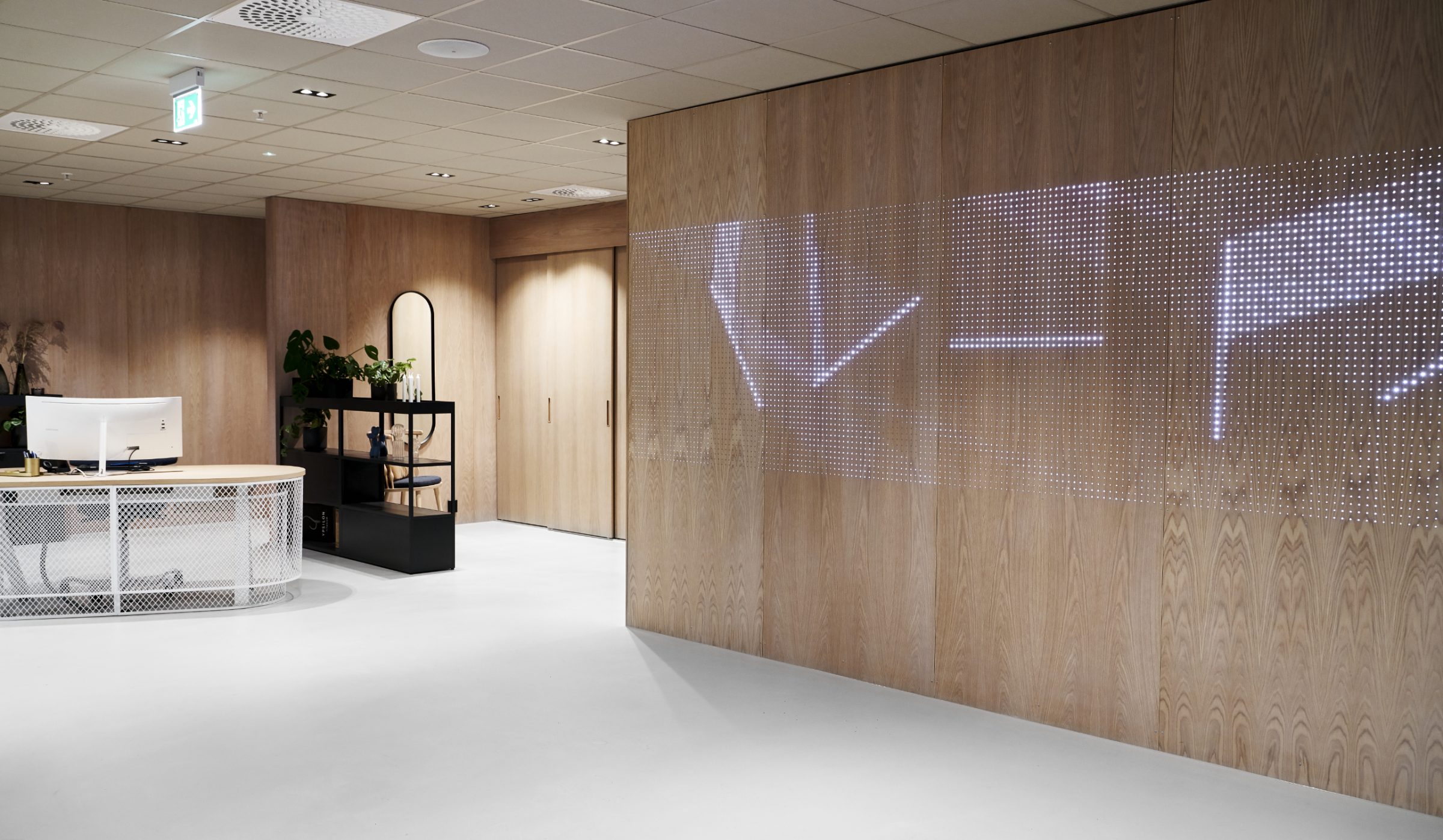 Moderne kontor med lysvegg og minimalistisk innredning