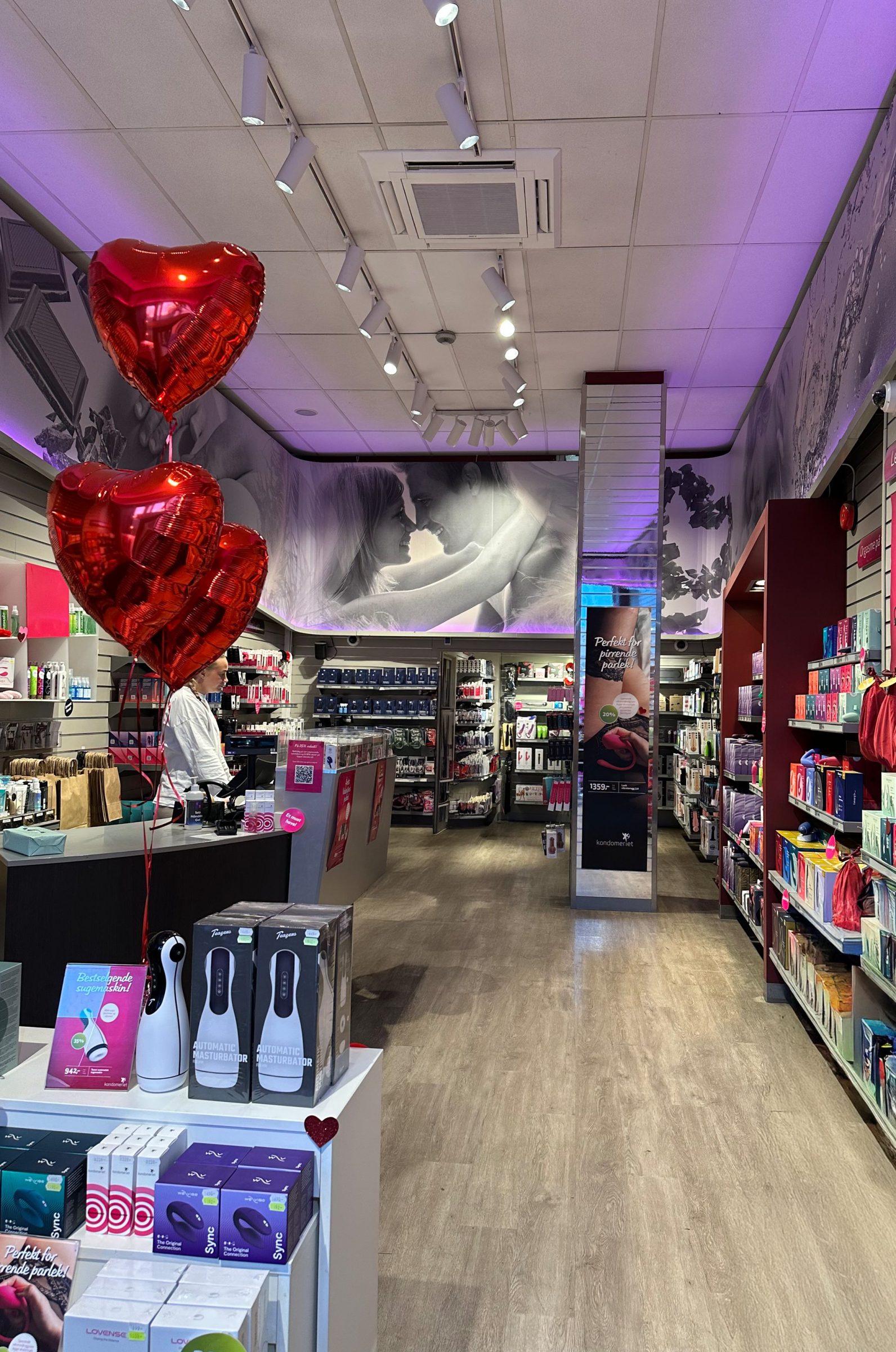 Butikkscene med røde ballonger og sexy plakater