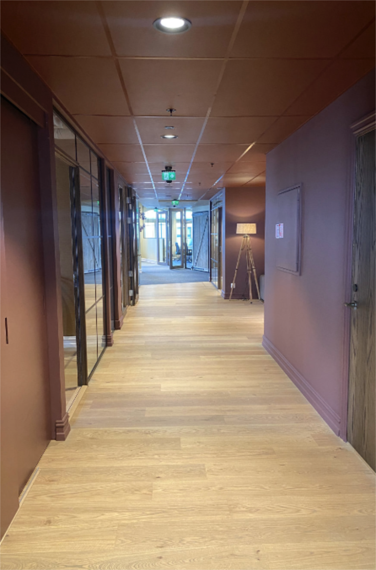 Langs korridor med glassdører og laminatgulv