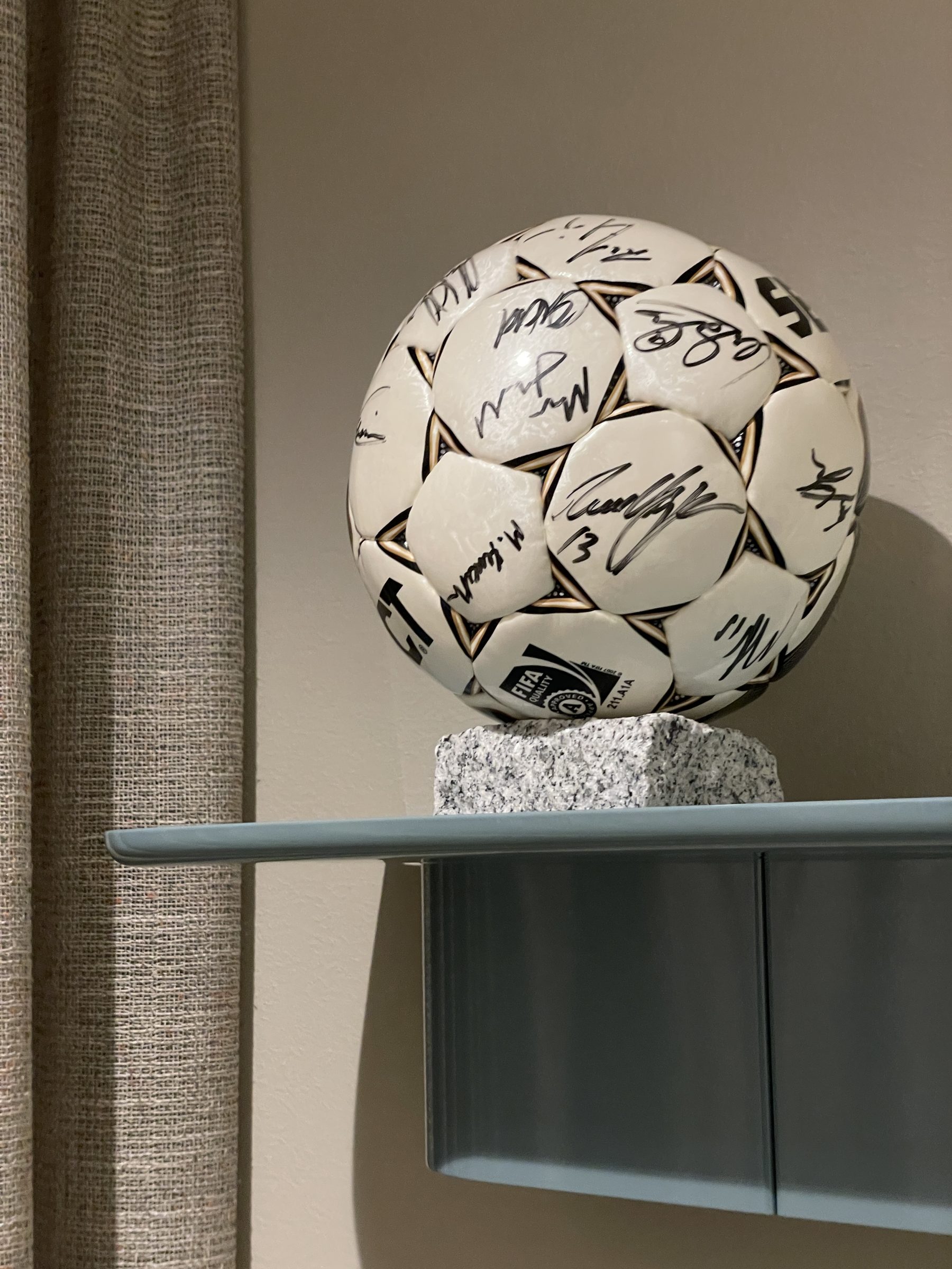 Fotball med signaturer på hylle