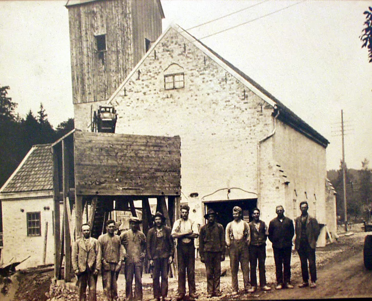 Historical factory building with workers and vintage vehicle