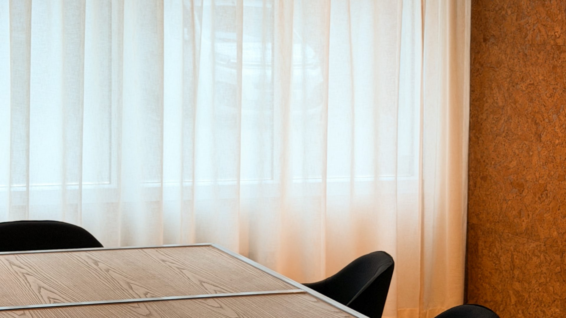 Minimalistisk møterom med trepanel og hengearmatur