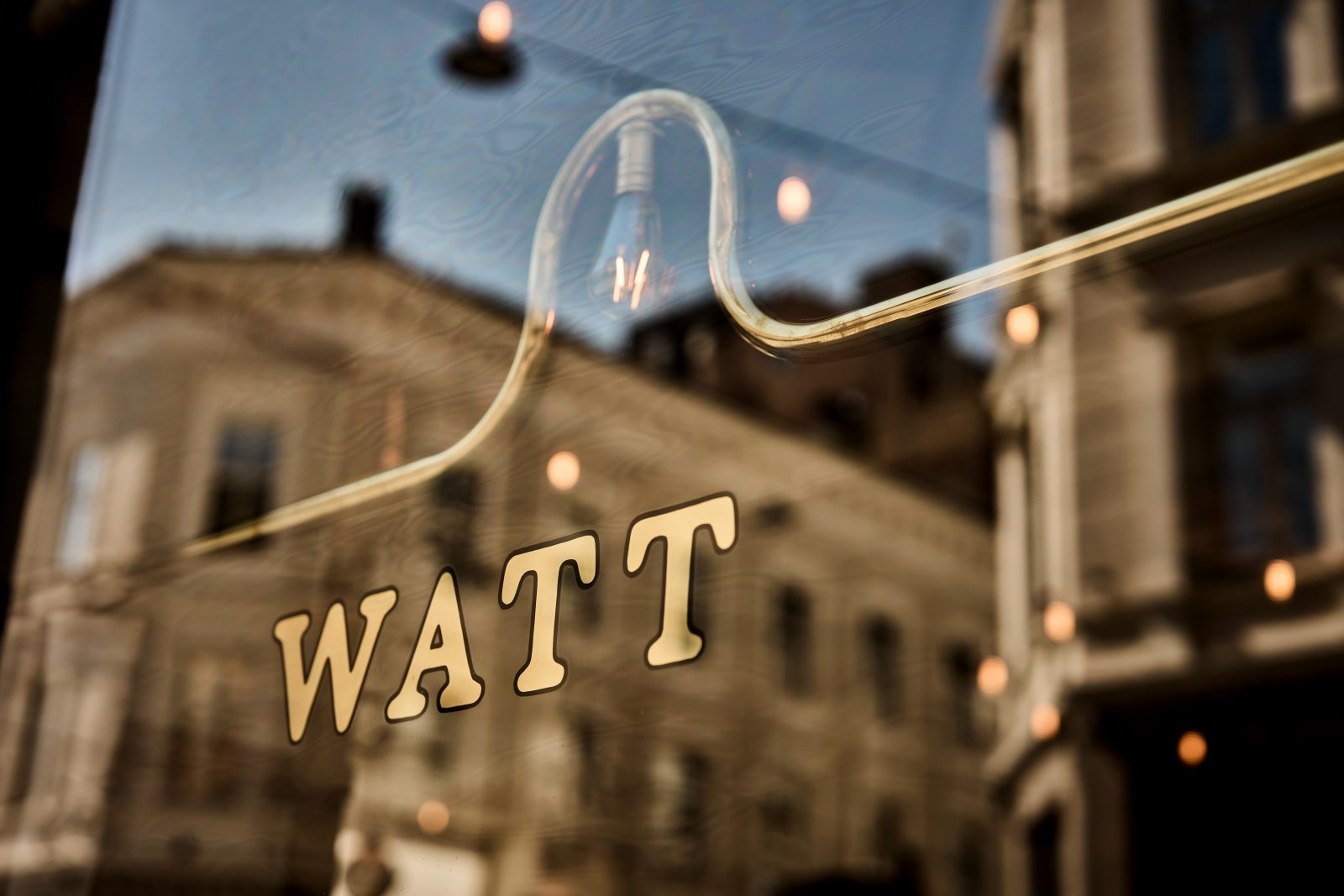 Watt-logo med glødende lyspære i glassvindu