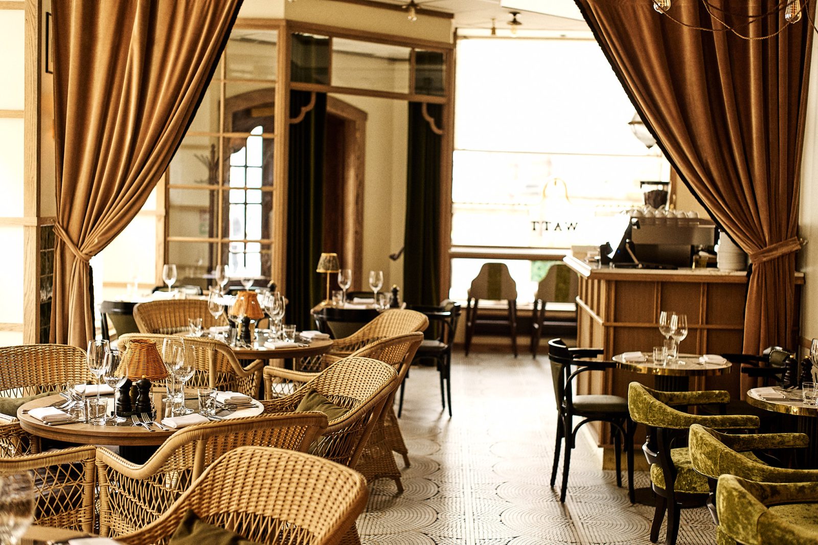 Elegant restaurant med rattan og grønn sammet